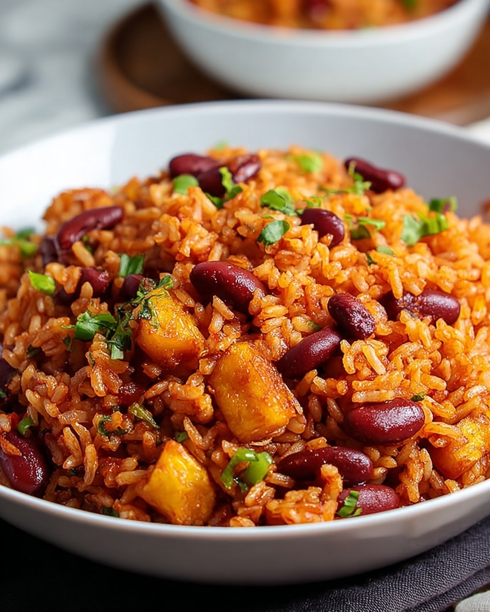 A close-up view of a black bowl filled with a single layer of seasoned rice mixed with red kidney beans, showing orange and reddish hues from spices. Bright green parsley leaves are scattered on top, adding contrast to the richly colored rice and beans. The rice grains look soft and fluffy, with some beans embedded, giving a textured appearance. The bowl sits on a white marbled surface with blurred green leaves in the background. Photo taken with an iphone --ar 4:5 --v 7