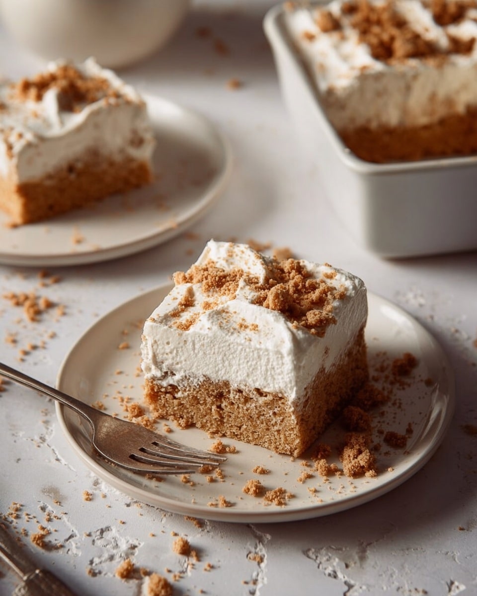 A close-up of a square slice of dessert with two visible layers, held above a white baking dish. The bottom layer is thick, light brown, and has a texture like soaked cake or soft pudding. The top layer is thick white whipped cream with a smooth and fluffy texture. Small crumbled golden brown pieces are sprinkled over the whipped cream. The background shows more pieces of the dessert in the white dish resting on a white marbled surface, with a simple grey wall behind. Photo taken with an iphone --ar 4:5 --v 7